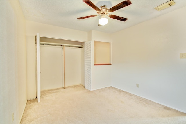 unfurnished bedroom featuring carpet floors, a closet, and ceiling fan