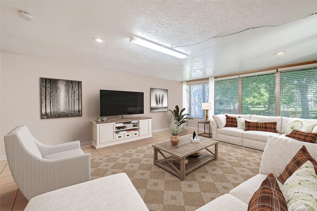 living area with recessed lighting, a textured ceiling, baseboards, and light tile patterned floors