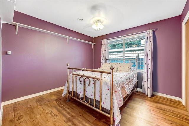 bedroom featuring wood finished floors, visible vents, and baseboards