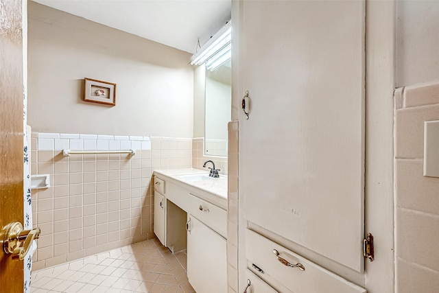 bathroom featuring tile patterned flooring, wainscoting, tile walls, and vanity