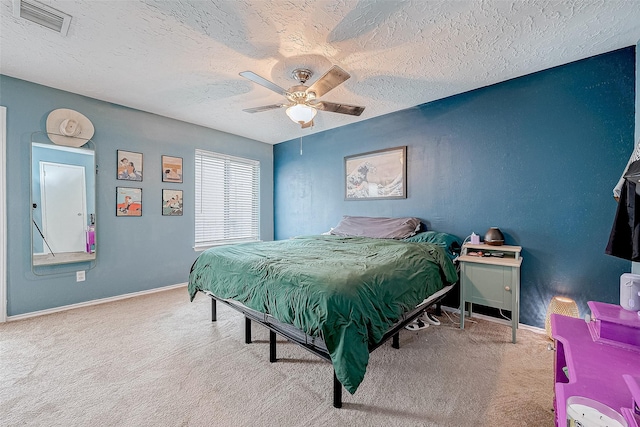 bedroom featuring carpet, ceiling fan, and a textured ceiling