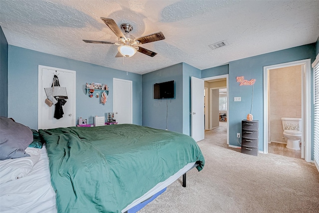 carpeted bedroom featuring ceiling fan, a textured ceiling, connected bathroom, and a closet