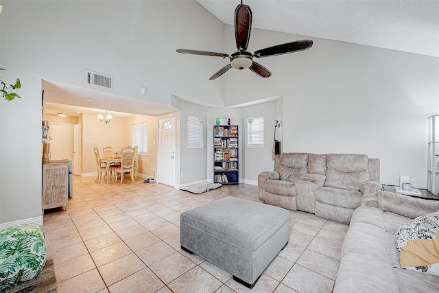 living room featuring high vaulted ceiling, light tile patterned flooring, and ceiling fan with notable chandelier