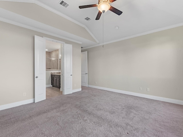 unfurnished bedroom featuring ceiling fan, ensuite bathroom, vaulted ceiling, light carpet, and ornamental molding