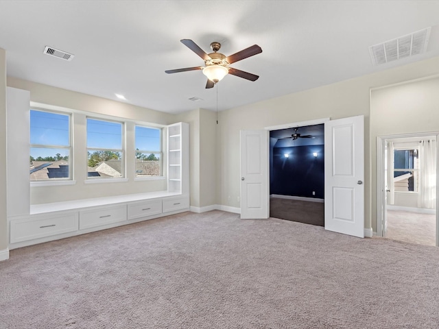 unfurnished bedroom with light colored carpet and ceiling fan