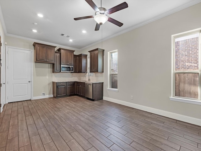 kitchen with dark brown cabinets, sink, ornamental molding, and stainless steel appliances