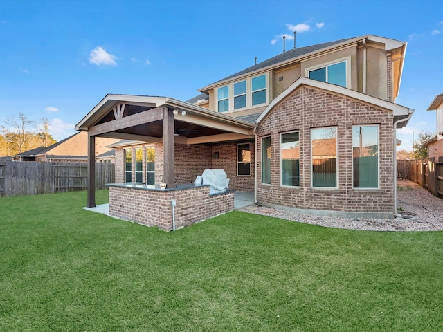 back of property with a patio area and a yard