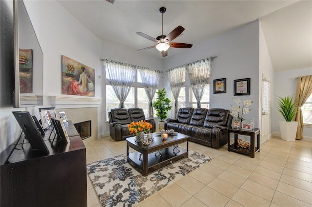 tiled living room with ceiling fan and a tiled fireplace