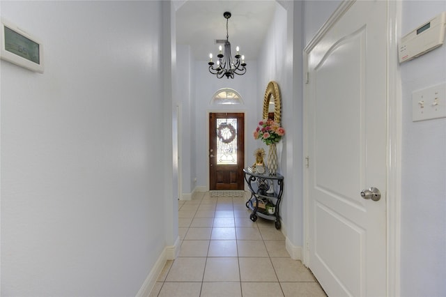 foyer entrance featuring light tile patterned flooring and an inviting chandelier