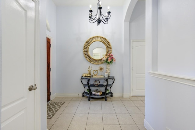 corridor featuring an inviting chandelier and light tile patterned flooring