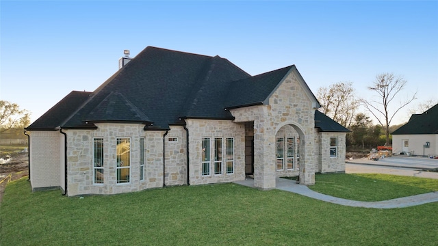 rear view of property featuring a yard