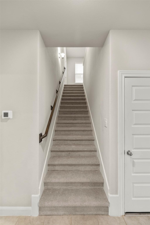 stairway with tile patterned flooring