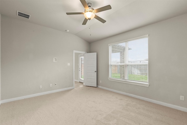 spare room featuring ceiling fan, light colored carpet, and vaulted ceiling