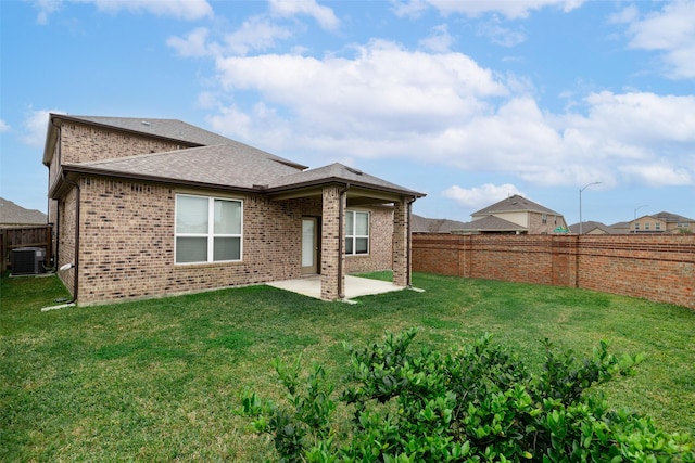 rear view of house featuring a patio, a lawn, and central air condition unit