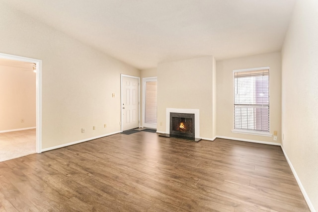 unfurnished living room with lofted ceiling and wood-type flooring