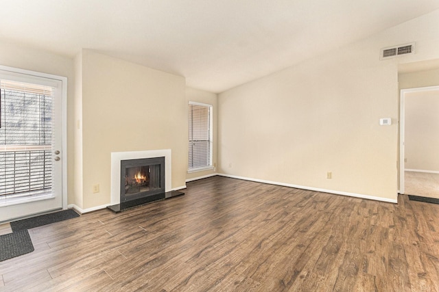 unfurnished living room featuring wood-type flooring and lofted ceiling