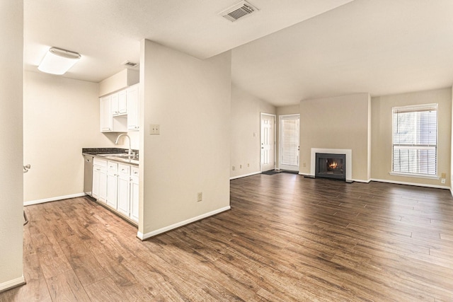 unfurnished living room with wood-type flooring and sink