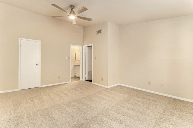 empty room featuring carpet flooring, ceiling fan, and a high ceiling