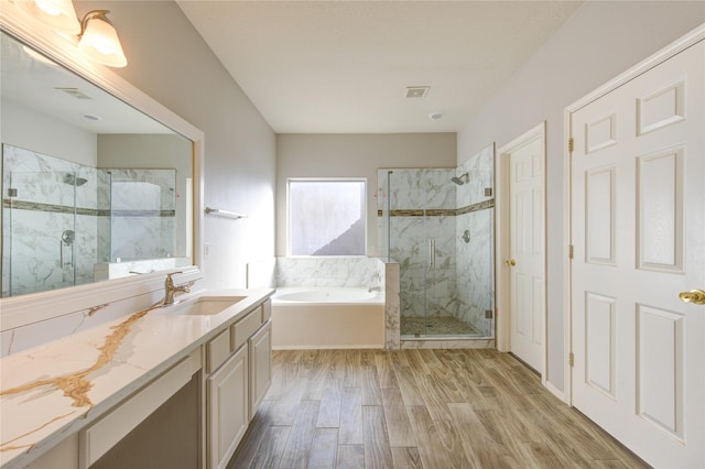 bathroom featuring hardwood / wood-style floors, vanity, and shower with separate bathtub