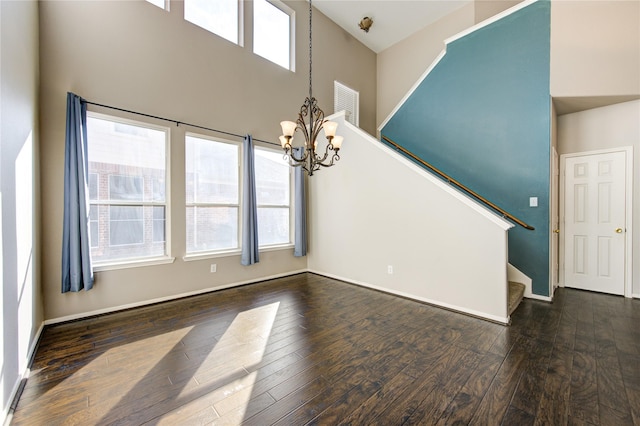 interior space featuring a notable chandelier, dark hardwood / wood-style floors, a high ceiling, and a wealth of natural light