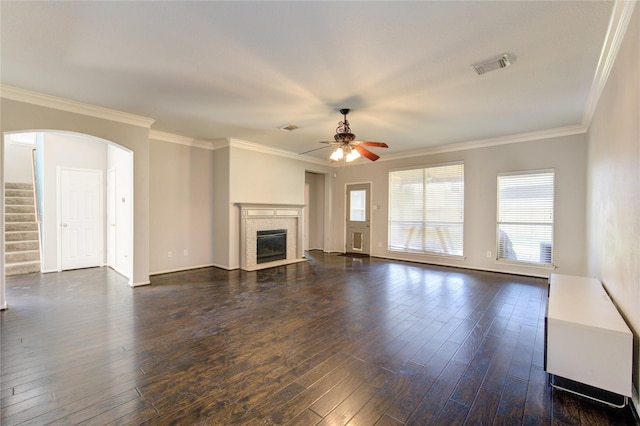 unfurnished living room with ceiling fan, dark hardwood / wood-style floors, ornamental molding, and a fireplace