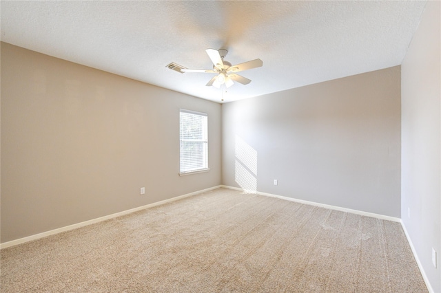 empty room featuring ceiling fan, carpet, and a textured ceiling