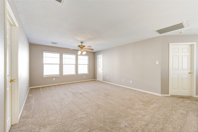 unfurnished room with a textured ceiling, light colored carpet, and ceiling fan