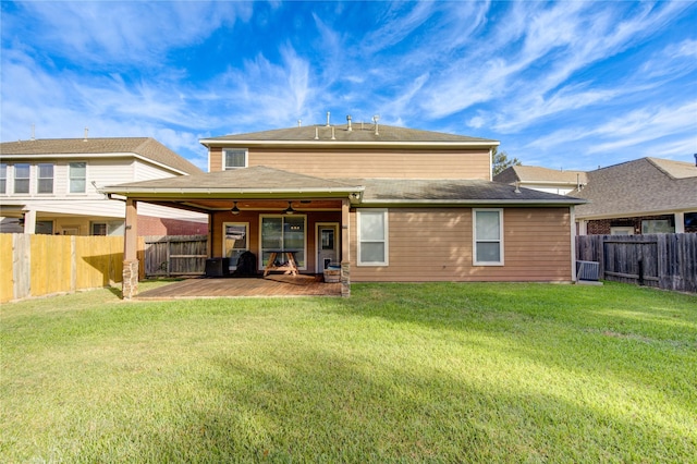 rear view of house with ceiling fan, a yard, and a patio