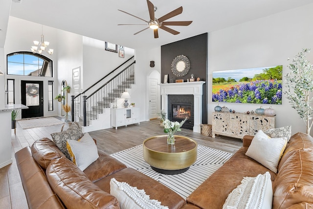 living room featuring a fireplace, hardwood / wood-style floors, and ceiling fan with notable chandelier