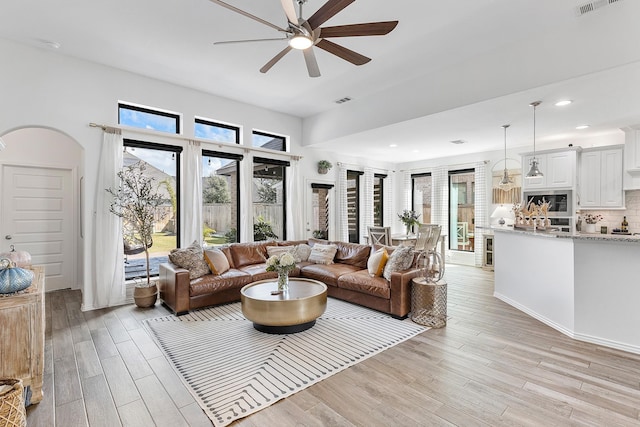 living room with light wood-type flooring and ceiling fan