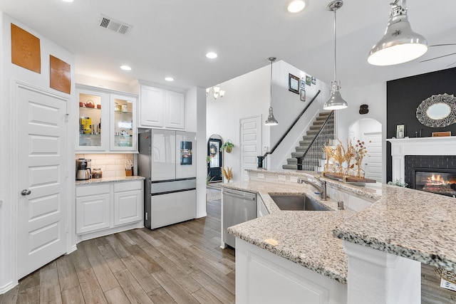 kitchen featuring white cabinetry, sink, hanging light fixtures, tasteful backsplash, and appliances with stainless steel finishes