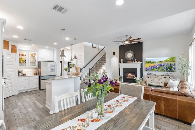 dining area with ceiling fan and a fireplace