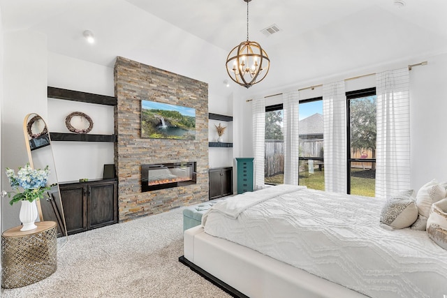 carpeted bedroom with a stone fireplace and a chandelier