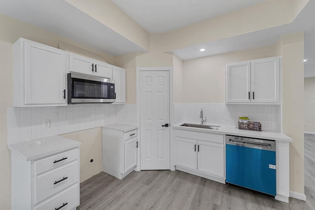 kitchen with sink, white cabinetry, stainless steel appliances, and tasteful backsplash