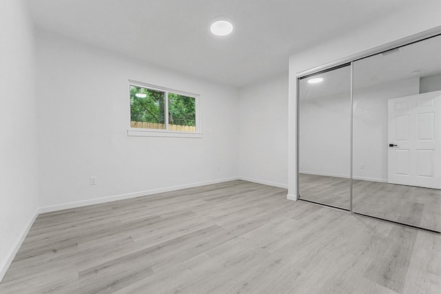 unfurnished bedroom with light hardwood / wood-style floors and a closet