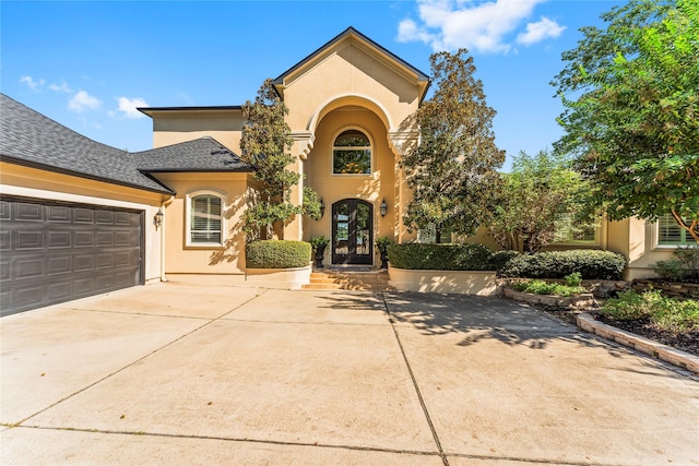 mediterranean / spanish home featuring a garage and french doors