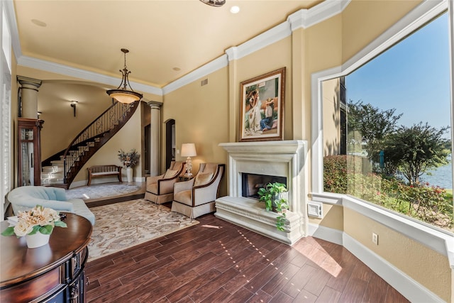 sitting room featuring crown molding and ornate columns