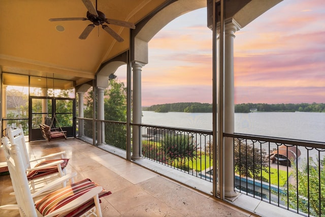 unfurnished sunroom with a water view, ceiling fan, lofted ceiling, and decorative columns