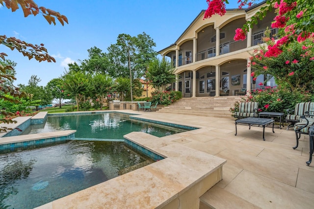 view of swimming pool featuring an in ground hot tub and a patio area