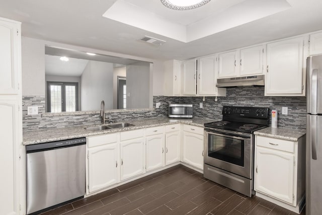 kitchen featuring backsplash, a raised ceiling, sink, white cabinetry, and stainless steel appliances