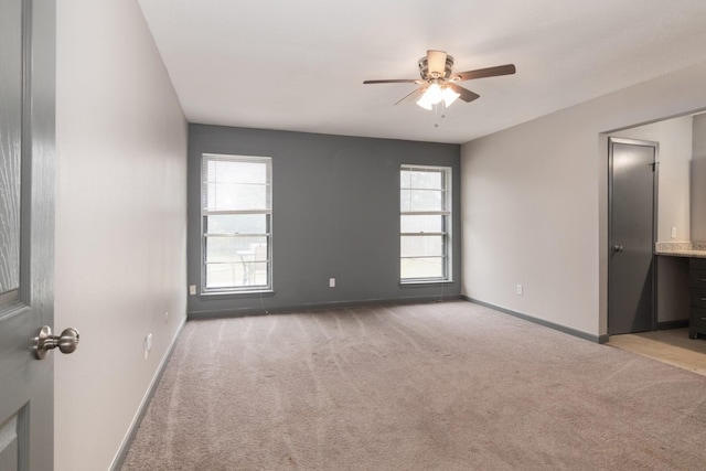 carpeted empty room featuring plenty of natural light and ceiling fan