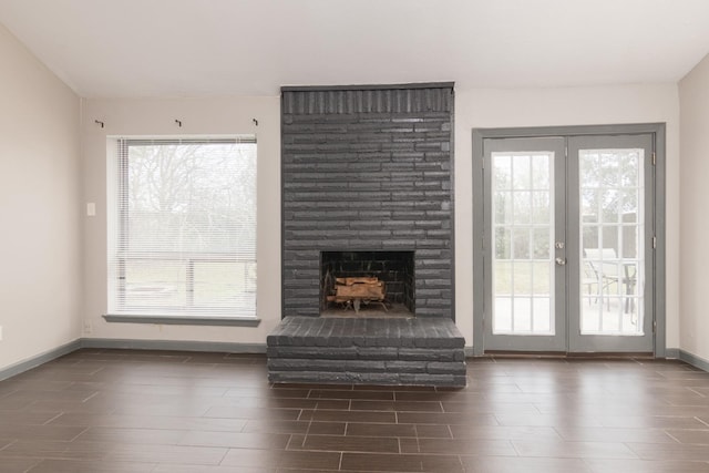 unfurnished living room featuring a fireplace and french doors