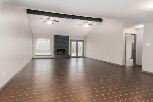 unfurnished living room with lofted ceiling with beams, french doors, and a brick fireplace