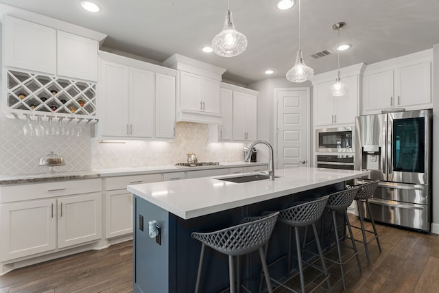 kitchen featuring sink, dark hardwood / wood-style flooring, pendant lighting, white cabinets, and appliances with stainless steel finishes