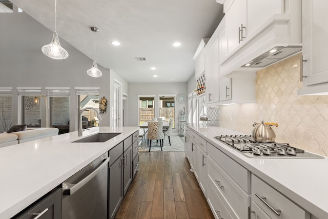 kitchen featuring hanging light fixtures, white cabinetry, sink, and stainless steel appliances