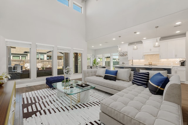 living room featuring light wood-type flooring and a towering ceiling