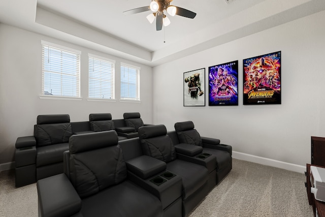 home theater with a raised ceiling, ceiling fan, and carpet floors