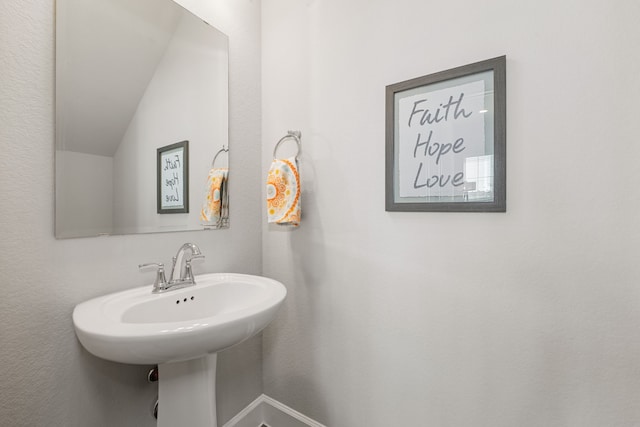 bathroom with lofted ceiling and sink