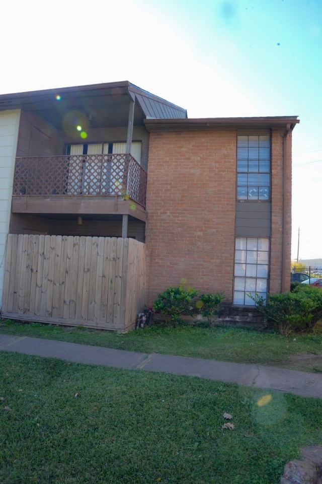 view of property exterior featuring a lawn and a balcony