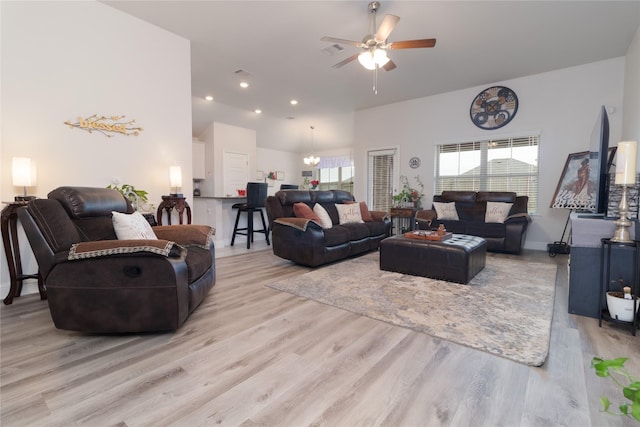 living room featuring ceiling fan with notable chandelier and light hardwood / wood-style floors